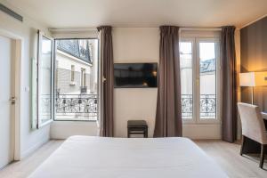 a hotel room with a bed and a window at Hotel de Flore - Montmartre in Paris