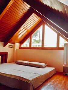 a bedroom with a bed with a large window at Little Things Earth - Pine villa in Auroville