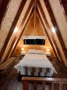 Schlafzimmer im Dachgeschoss mit einem Bett und einem Fenster in der Unterkunft Cabaña Pumol in Futrono