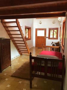 a bedroom with a bed and a staircase in a house at Little Things Earth - Pine villa in Auroville