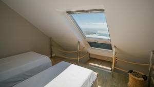 a small room with two beds and a window at Lapoint Surf Camp Ericeira in Ericeira +32 photos