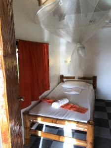 sypialnia z łóżkiem z czerwoną zasłoną w obiekcie Cuestas Beach Resort and Restaurant w mieście Badian