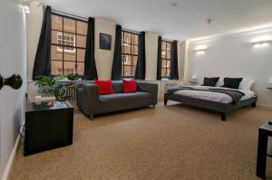 a living room with two couches and a bed and windows at Casa lujosa de 4 habitaciones cerca un minuto de la estación in London