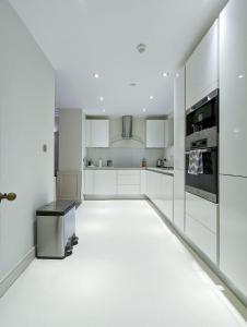 a white kitchen with white cabinets and appliances at Casa lujosa de 4 habitaciones cerca un minuto de la estación in London