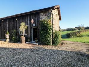 a barn with a door and ivy at Orchard Retreat in Crediton