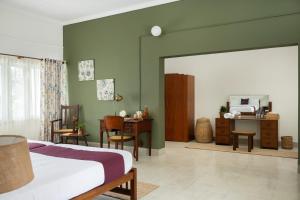 a bedroom with a bed and a desk and a mirror at The Sacred Lotus Ayurveda Wellness Retreat in Cochin