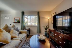 ein Wohnzimmer mit einem Sofa und einem Flachbild-TV in der Unterkunft Loveland Home with Private Hot Tub and Wood Fireplace! in Loveland