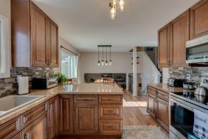 a large kitchen with wooden cabinets and a sink at Loveland Home with Private Hot Tub and Wood Fireplace! in Loveland