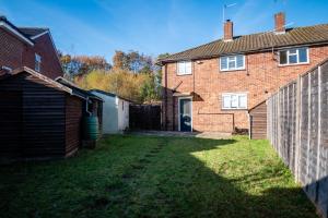 an empty backyard of a brick house with a fence at Ashbourne House - Close to Central Woking in Woking