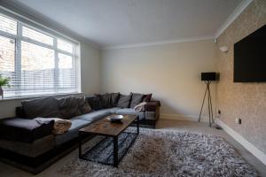 a living room with a couch and a table at Ashbourne House - Close to Central Woking in Woking