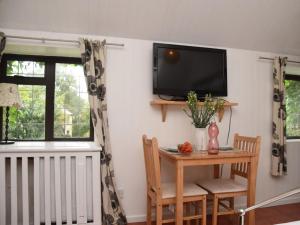Egloskerryにある1 bed property in Crackington Haven 36500の壁にテーブルとテレビが備わる部屋