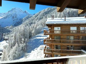 una vista dal balcone di un hotel nella neve di Chalet Les Rahâs by Mrs Miggins a Grimentz