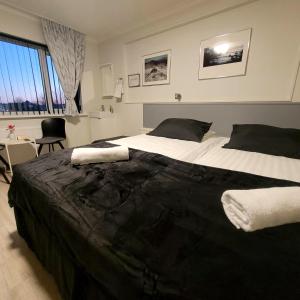 een slaapkamer met een groot bed met zwart-witte lakens bij B&B Guesthouse - Bed and Breakfast Keflavik Centre in Keflavík