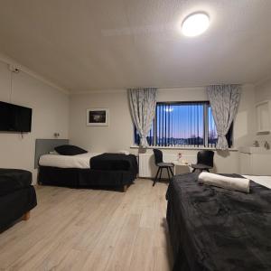 a hotel room with two beds and a table and chairs at B&B Guesthouse - Bed and Breakfast Keflavik Centre in Keflavík