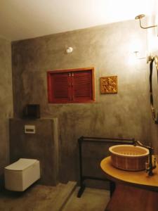 uma casa de banho com um lavatório e um WC em Little Things Earth - Pine villa em Auroville