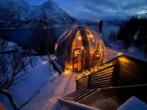 un iglú con luces en la nieve por la noche en Lofoten glampingdome, en Myrland