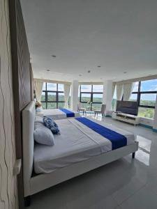 EliJosh Resort and Events Place في Silang: غرفة نوم بسريرين في غرفة بها نوافذ
