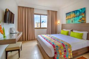 Habitación de hotel con cama grande y TV en El Oumara Hotel en Túnez