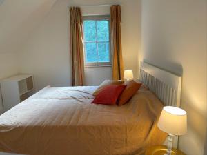 ein Schlafzimmer mit einem Bett mit zwei Kissen und einem Fenster in der Unterkunft Schellnhof Forsthaus am Waldrand in Nidda