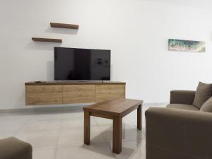 a living room with a tv and a coffee table at Marsaxlokk Fishing Village - Two Bedroom Apartment - 3rd Floor in Marsaxlokk