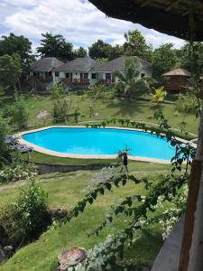 a person standing in front of a swimming pool at Cuestas Beach Resort and Restaurant in Badian