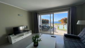 a living room with a tv and a sliding glass door at Apt. El Guirre Nº 9 in Valle Gran Rey