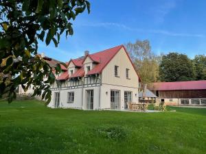 una gran casa blanca con techo rojo en Schellnhof Forsthaus am Waldrand, en Nidda