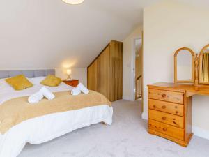 a bedroom with a large bed and a wooden dresser at 2 Bed in Lampeter 86507 in Cellan
