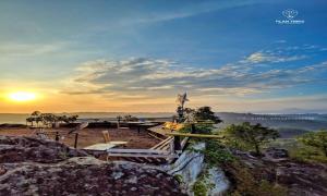 a star statue on top of a mountain with the sunset at Eagles nest in Wayanad