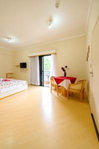 a bedroom with a table and chairs and a bed at Rovi Plaza Hotel in Serra Negra