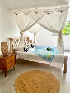 a bedroom with a canopy bed and a wooden table at Vanille et Vahiné FR2PF8AL in Grand-Bourg +39 photos
