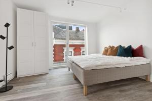 a white bedroom with a bed and a window at Leilighet i Stavanger in Stavanger