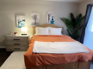 a bedroom with a bed with an orange and white comforter at Mimosa Place Newly remodeled in 2023 in Rogers