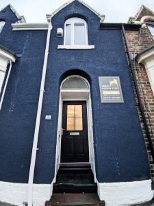 un edificio azul con una puerta negra y una ventana en A&A Luxury Stay Alice, en Sunderland