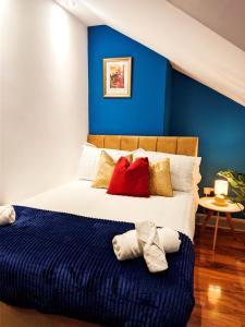 a bedroom with a bed with a blue wall at A&A Luxury Stay Alice in Sunderland