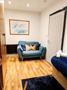 sala de estar con sofá azul y puerta en A&A Luxury Stay Alice, en Sunderland