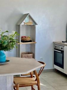 - une cuisine avec une table, des chaises et une cuisinière dans l'établissement Vanille et Vahiné FR2PF8AL, à Grand-Bourg
