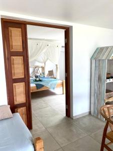 a bedroom with a bed and a glass door at Vanille et Vahiné FR2PF8AL in Grand-Bourg