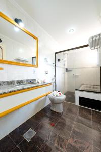 uma casa de banho com um WC e uma cabina de duche em vidro. em Rovi Plaza Hotel em Serra Negra