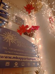 un cartel para el apartamento de la playa con luces de Navidad en The 727 Sottomarina, en Sottomarina