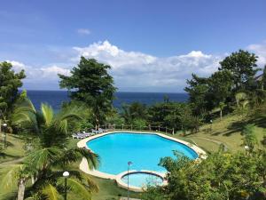 a swimming pool with the ocean in the background at Cuestas Beach Resort and Restaurant in Badian