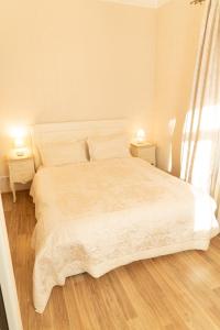 1 dormitorio con 1 cama blanca y 2 mesitas de noche en Beautiful, spacious apartment! Free Private Parking, en Riga