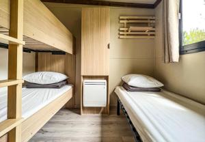 a room with two bunk beds and a window at CAMPING ONLYCAMP VAUBAN in Neuf-Brisach