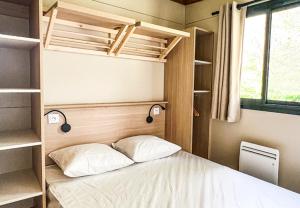 a small bedroom with a bed and a window at CAMPING ONLYCAMP VAUBAN in Neuf-Brisach