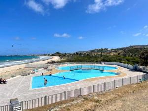uma vista para duas piscinas ao lado de uma praia em Appartement Saint-Martin , 3 pièces, 4 personnes - FR-1-734-37 em São Martinho