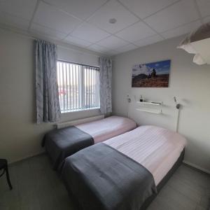 a hotel room with two beds and a window at B&B Guesthouse - Bed and Breakfast Keflavik Centre in Keflavík