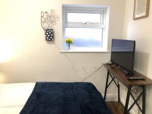 a bedroom with a bed and a desk with a computer on it at Tiny small cosy studio apartment in Liverpool