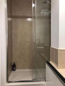 a shower with a glass door in a bathroom at Tiny small cosy studio apartment in Liverpool