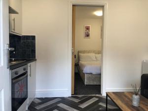 a room with a kitchen and a bedroom with a bed at Tiny small cosy studio apartment in Liverpool