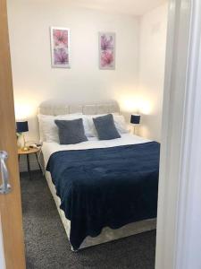 a bedroom with a large bed with blue sheets and pillows at Tiny small cosy studio apartment in Liverpool